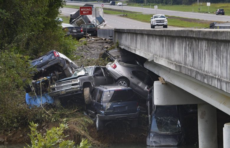 Cars are stacked on top of each other on the banks of Blue Creek being swept up in flood water, Monday, Aug. 23, 2021, in Waverly, Tenn. Heavy rains caused flooding in Middle Tennessee days ago and have resulted in multiple deaths as homes and rural roads were washed away. (AP Photo/John Amis) TNJA109 TNJA109
