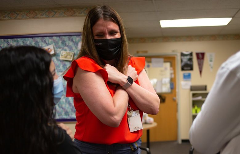 Katie Humphrey, counselor at Columbia Middle School, and two students give themselves “Wakanda hugs” in lieu of the real thing before the students move on to high school. May 26, 2021. Photo by Sara Hertwig