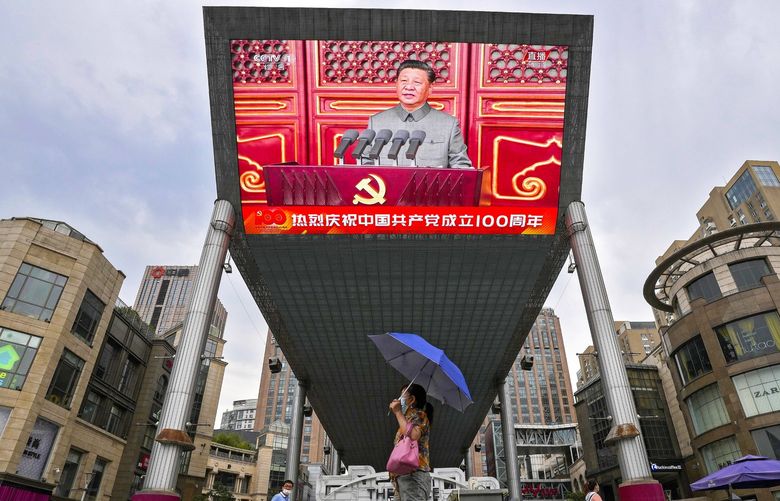 People walk past a large video screen outside a shopping mall showing Chinese President Xi Jinping speaking during an event to commemorate the 100th anniversary of China’s Communist Party at Tiananmen Square in Beijing, Thursday, July 1, 2021. China’s ruling Communist Party is marking the 100th anniversary of its founding with speeches and grand displays intended to showcase economic progress and social stability to justify its iron grip on political power. (AP Photo/Andy Wong) XAW102