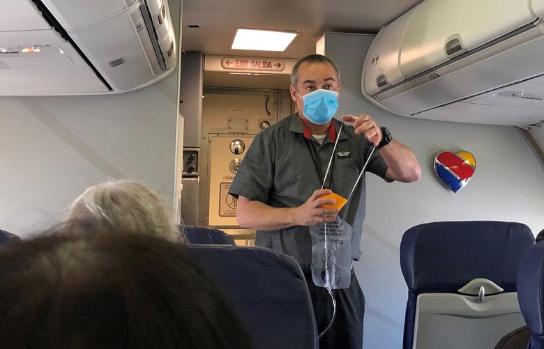 A flight attendant demonstrates the use of an oxygen mask at the outset of flight from Burbank to Las Vegas in June. A survey of flight attendants found unruly passengers are an ongoing problem. (Christopher Reynolds/Los Angeles Times/TNS) 