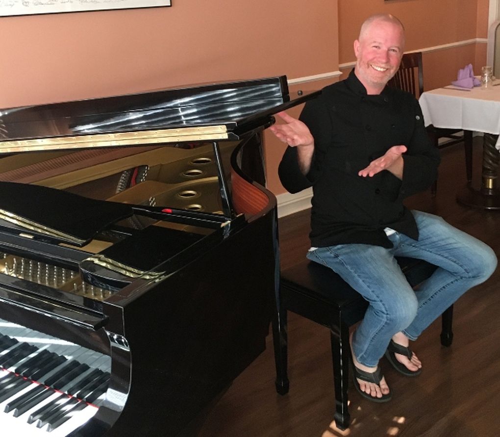 Jason Moore, former manager of Tula’s jazz club, shows off the new baby grand piano at Calluna, the restaurant he opened in Ravenna that is now booking jazz acts. (Paul de Barros)