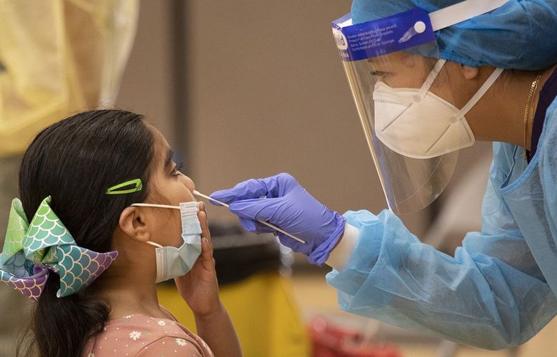 Nurse Cindy Bayasgalan swabs first-grader Alyssa Ponce for a coronavirus infection at a mobile testing site at Telfair Elementary School in Pacoima last week. (Myung J. Chun/Los Angeles Times/TNS) 24550955W 24550955W