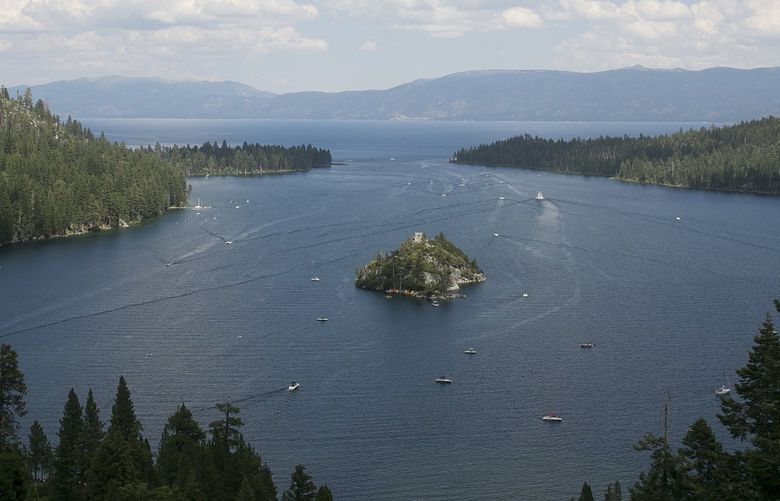 FILE – In this Aug. 8. 2017 file photo, boats ply the waters of Emerald Bay of Lake Tahoe, near South Lake Tahoe, Calif. The Caldor Fire in Northern California is churning through and threatening places that have been cherished getaways for generations of Californians and others. The entire town of South Lake Tahoe lies in its path. (AP Photo/Rich Pedroncelli, File) FX508 FX508