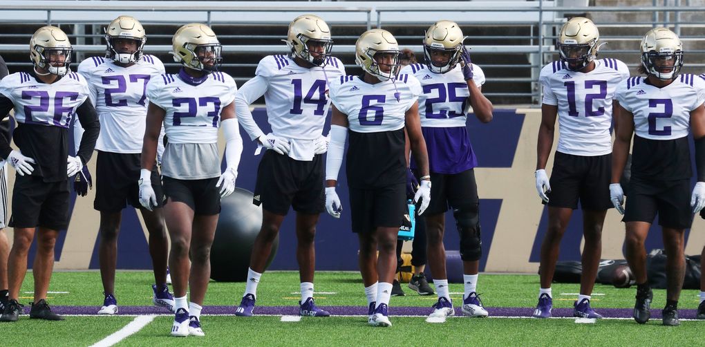 Defensive players, including defensive back Cameron Williams (6) who had two interceptions, wait for the next drill during University of Washington football practice, Sunday, Aug. 8, 2021 in Seattle. This is UW football camp day 3. (Ken Lambert / The Seattle Times)