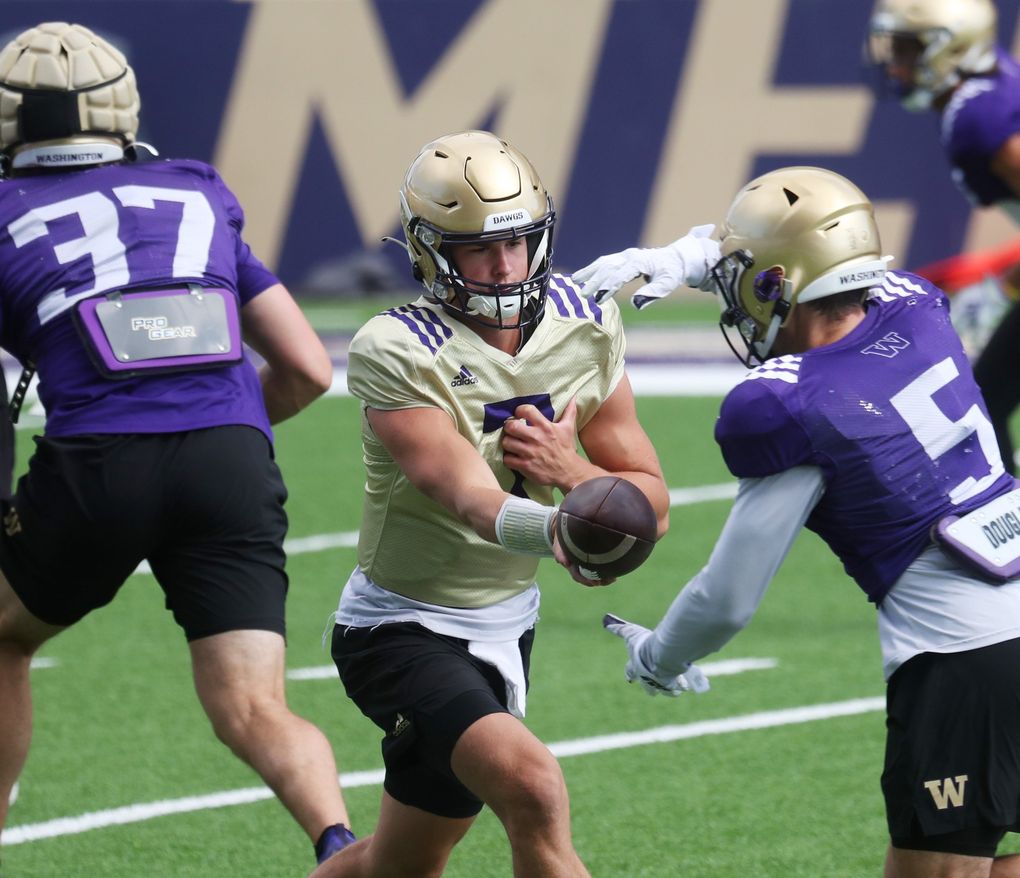 Quarterback Sam Huard (7) runs a drill, handing off to tailback Sean McGrew (5) during University of Washington football practice, Sunday, Aug. 8, 2021 in Seattle. This is UW football camp day 3. (Ken Lambert / The Seattle Times)