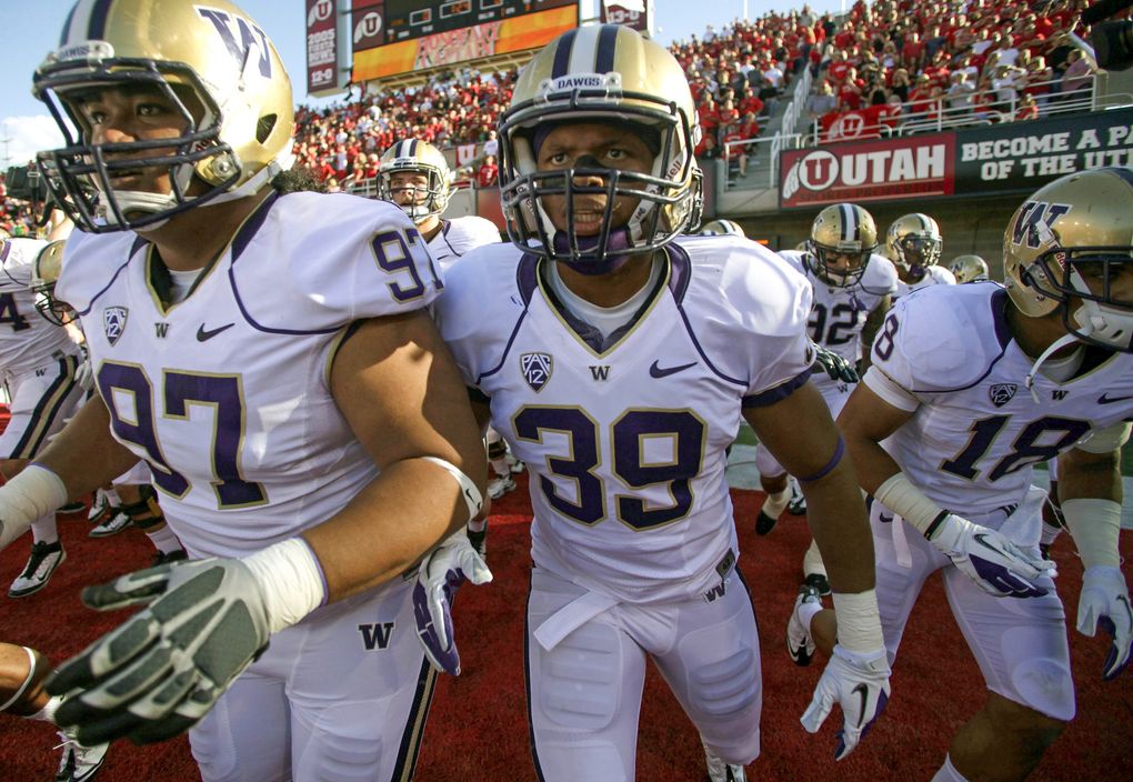 Washington defensive tackle Lawrence Lagafuaina (97) and safety Greg Walker (39) take the field with their team before an NCAA college football game against Utah on Saturday, Oct. 1, 2011, in Salt Lake City. (Jim Urquhart / The Associated Press)