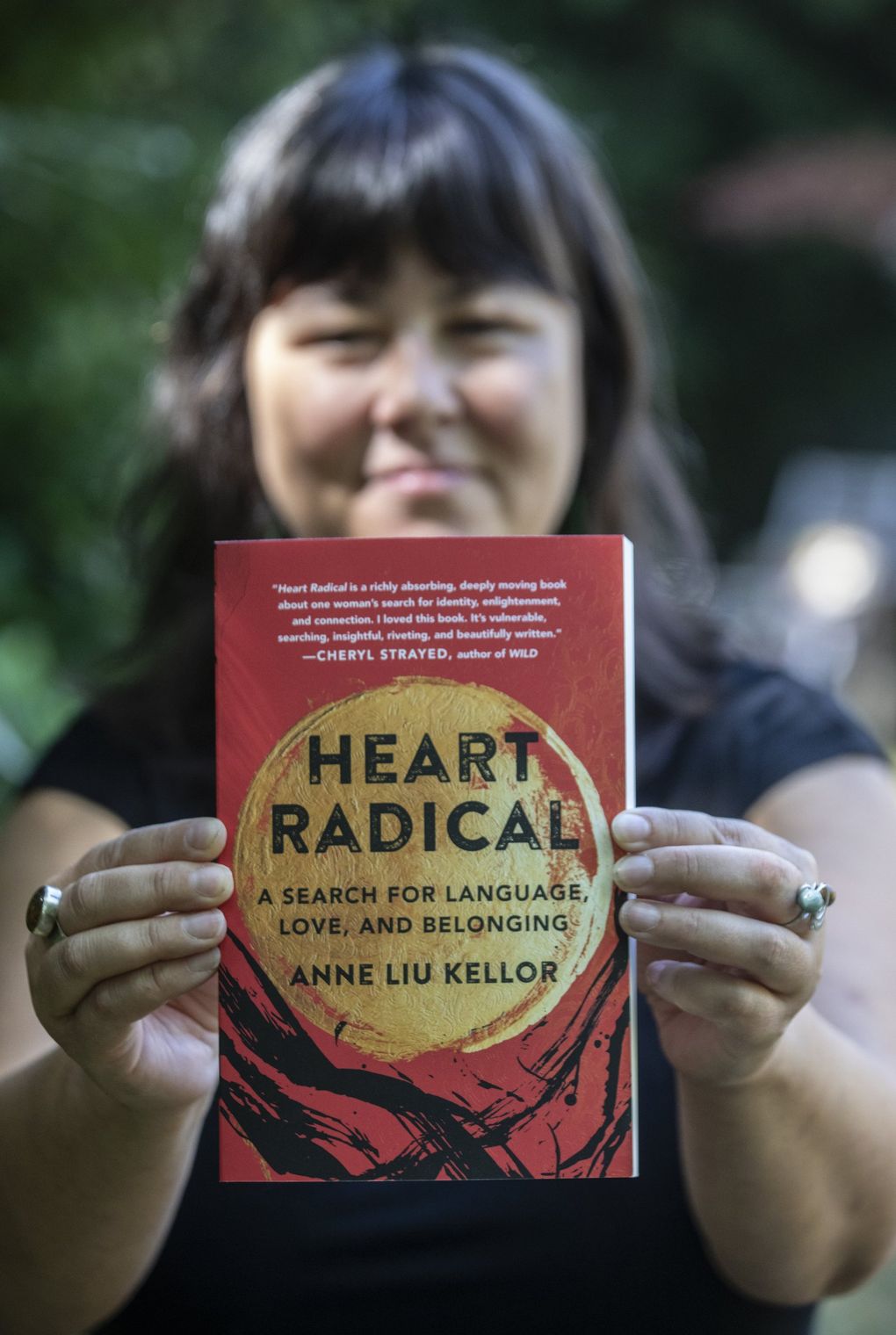 Anne Liu Kellor shows off her debut memoir “Heart Radical: A Search for Language, Love, and Belonging” Aug. 24, 2021, in North Seattle. (Steve Ringman / The Seattle Times)