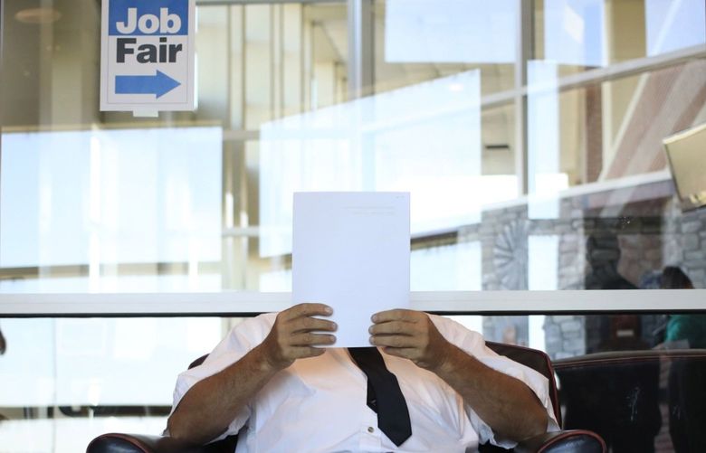 A job seeker reads paperwork during a Job News USA career fair in Louisville, Ky., on June 23, 2021. MUST CREDIT: Bloomberg photo by Luke Sharrett.