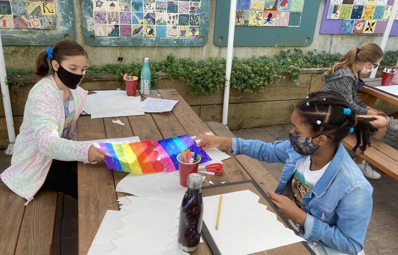 Two 5th graders Ana K. (left) and Kadyn H. (right), collaborate on an art project at Seattle Girls School in 2020.
