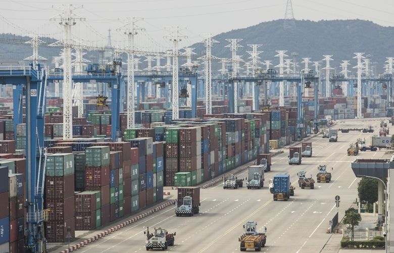 Containers sit stacked next to gantry cranes as trucks operate at the Port of Ningbo-Zhoushan in Ningbo, China, on Wednesday, Oct. 31, 2018.