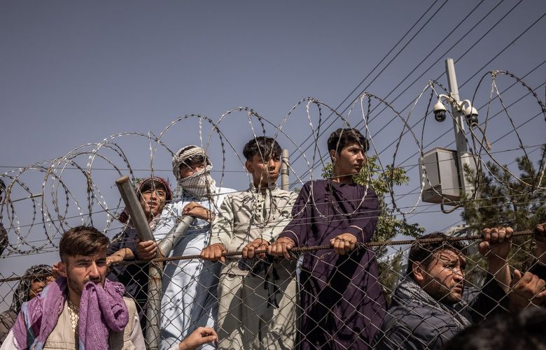 People gather in front of the international airport in Kabul, Afghanistan on Monday, Aug. 16, 2021, after the Taliban took control of the country. (Jim Huylebroek/The New York Times) XNYT154 XNYT154