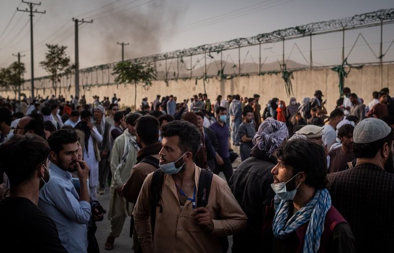 People hoping to gain access, gather outside the international airport in Kabul, Afghanistan on Aug. 25, 2021. With days remaining until a withdrawal deadline, thousands of U.S. citizens and tens of thousands of Afghans who qualify for special immigration visas are waiting for evacuation. (Jim Huylebroek/The New York Times) XNYT12 XNYT12