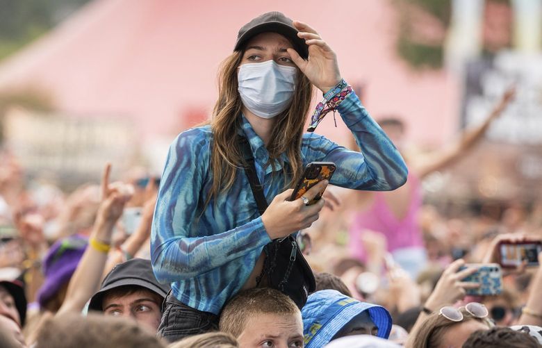 A member of the public wears a surgical mask amongst the crowd at the Reading Music Festival, England, Saturday, Aug. 28, 2021. (AP Photo/Scott Garfitt) REA121 REA121