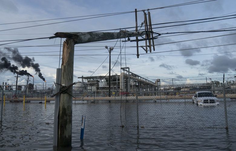 Broken power lines, destroyed by Hurricane Ida, are seen along a highway near a petroleum refinery on August 30, 2021 outside LaPlace, Louisiana. MUST CREDIT: Washington Post photo by Michael Robinson Chavez