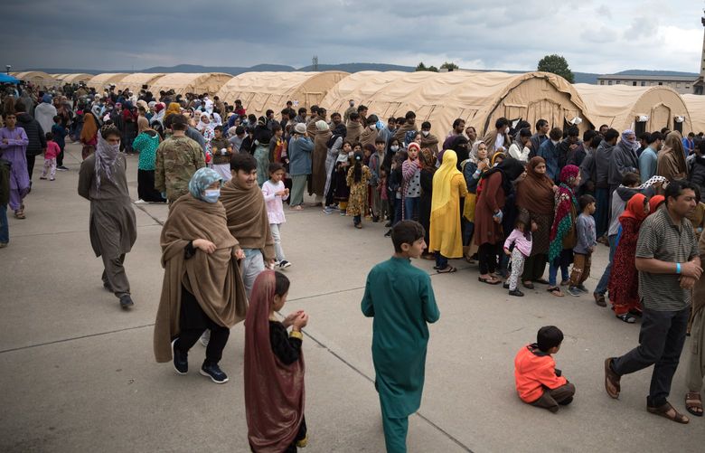 Afghan evacuees queue for meals at Ramstein Air Base in Germany, Monday, August 30, 2021. When the first arrivals touched down from Kabul on Aug. 20, Ramstein’s commander told reporters the base could hold 5,000 evacuees. Two weeks later, it is housing nearly three times as many. (Gordon Welters/The New York Times) XNYT116 XNYT116