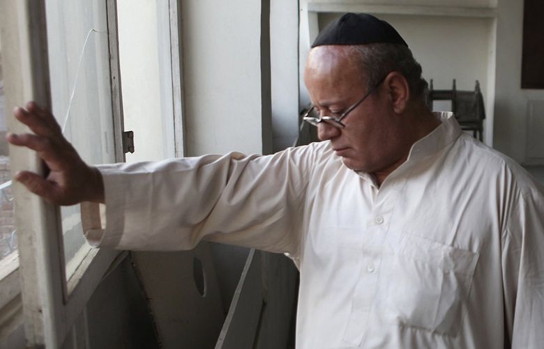 FILE – In this Aug. 29, 2009 file photo, Zebulon Simentov, the last known Jew living in Afghanistan, closes the window to the synagogue he cares for in his Kabul home. Simentov who prayed in Hebrew, endured decades of war as the country’s centuries-old Jewish community rapidly dwindled has left the country. The Taliban takeover in August, 2021, seems to have been the last straw. (AP Photo/David Goldman, File) AFGTH101 AFGTH101