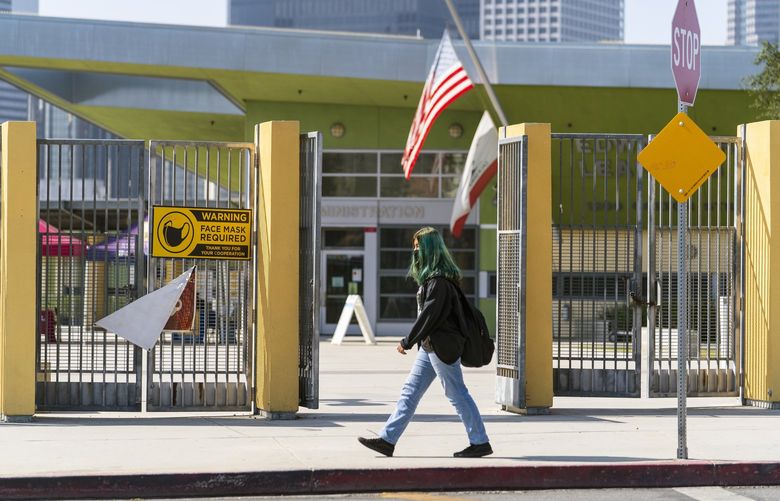 A student walks past the open doors of the Edward R. Roybal Learning Center in Los Angeles Thursday Sept. 9, 2021. The Los Angeles board of education is expected to vote Thursday, on whether to require all students 12 and older to be fully vaccinated against the coronavirus to participate in on-campus instruction in the nation’s second-largest school district. (AP Photo/Damian Dovarganes) CADD407 CADD407