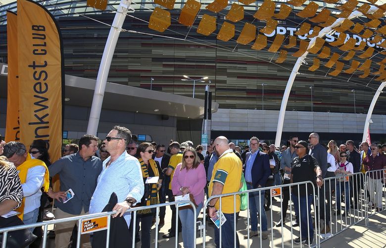 Fans lineup to enter the stadium ahead of the Rugby Championship game between the All Blacks and the Wallabies in Perth, Australia, Sunday, Sept. 5, 2021. While the cities of Sydney and Melbourne in the east have been in strict lockdown, the Western Australia state capital Perth has largely remained open for business behind its closed border. Masks are rarely seen and bars and nightclubs are open. But states that remain virtually COVID-free, including Western Australia, are now under mounting pressure to share the nation’s pandemic pain by opening their borders in the interests of opening the national economy.(AP Photo/Gary Day) AUS104 AUS104