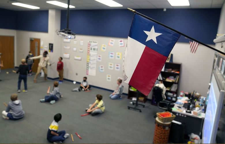 A Texas flag is displayed in an ementary school music class at Tibbals Elementary School in Murphy, Texas, Thursday, Dec. 3, 2020. Texas Gov. Greg Abbot’s statewide mask order does not mandate face covering for children under the age of 10, allowing some school districts to not require masks for children leaving the choice of mask use up to the parents. (AP Photo/LM Otero)
