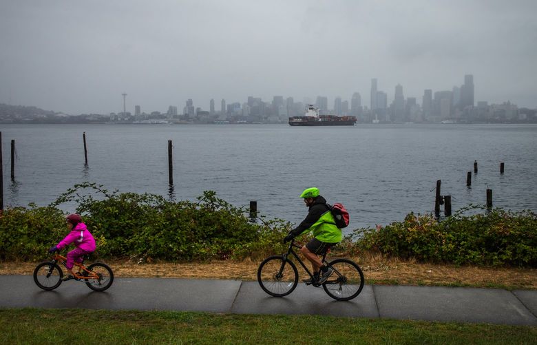 Cyclists brave a light rain for a gray skyline view along Harbor Avenue in West Seattle, Sunday September 12, 2021.