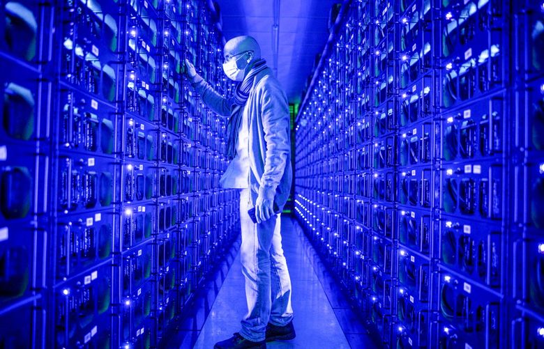 An employee wearing a protective face mask inspects mining rigs mining the Ethereum and Zilliqa cryptocurrencies at the Evobits crypto farm in Cluj-Napoca, Romania, on Wednesday, Jan. 22, 2021.Photographer: Akos Stiller/Bloomberg 775614384