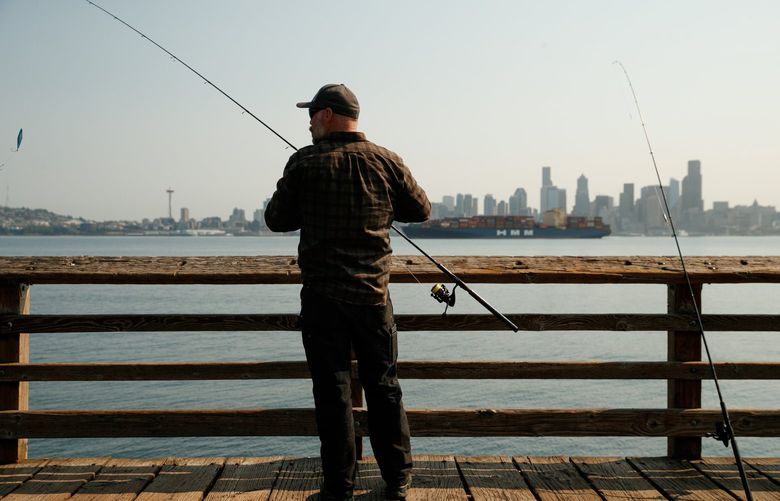 Jason Williams fishes for chinook salmon in West Seattle Monday, August 2, 2021. Smoke from the wildfires in Oregon and California is expected to be in the atmosphere in Seattle this week. 217801