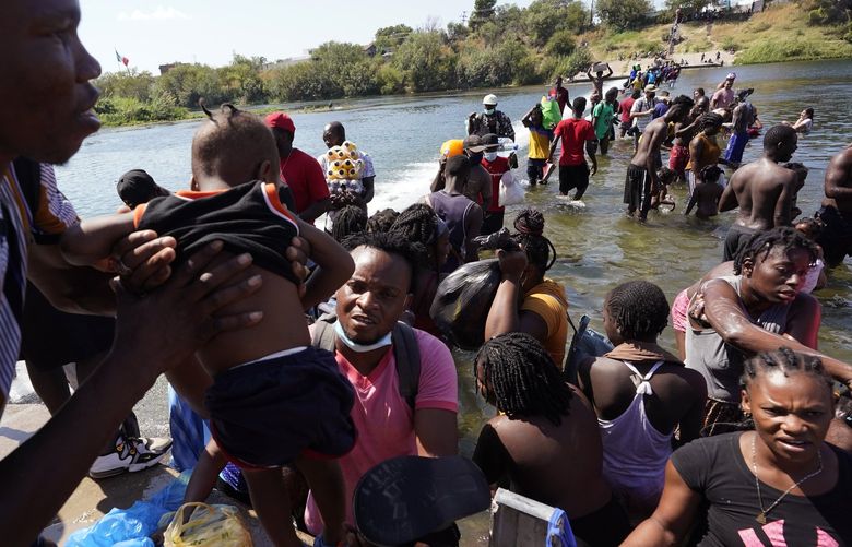 Haitian migrants use a dam to cross to and from the United States from Mexico, Friday, Sept. 17, 2021, in Del Rio, Texas. Thousands of Haitian migrants have assembled under and around a bridge in Del Rio presenting the Biden administration with a fresh and immediate challenge as it tries to manage large numbers of asylum-seekers who have been reaching U.S. soil. (AP Photo/Eric Gay) TXEG117 TXEG117