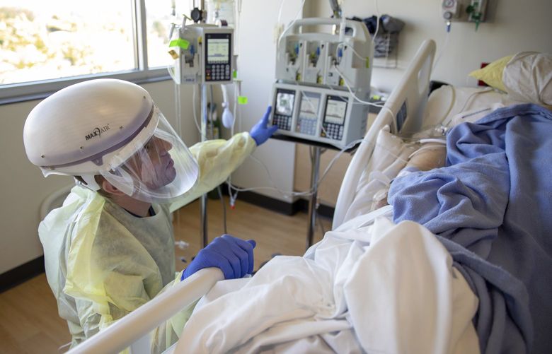 In this photo provided by the Defense Visual Information Distribution Service, U.S. Army 1st Lt. Blaine Woodcock, a critical care nurse, provides care to a COVID-positive patient during the COVID-19 response operations at Kootenai Health regional medical center in Coeurâ€¯d’Alene,â€¯Idaho,â€¯on Sept. 6, 2021. Roughly 11,000 kids in Coeur d’Alene were getting ready for their first day of school when Idaho public health officials announced this week that northern hospitals were so crowded with coronavirus patients that they would be allowed to ration health care. Kootenai Health has had to move some patients into a conference room and get help from the military to deal with the flood of coronavirus patients. (Sgt. Kaden D. Pitt/DVIDS U.S. Army via AP) FX409 FX409