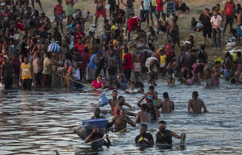 EDS NOTE: NUDITY – Migrants, many from Haiti, wade across the Rio Grande from Del Rio, Texas, to return to Ciudad AcuÃ±a, Mexico, Sunday, Sept. 19, 2021, to avoid deportation to Haiti from the U.S. The U.S. is flying Haitians camped in a Texas border town back to their homeland and blocking others from crossing the border from Mexico in a massive show of force that signals the beginning of what could be one of America’s swiftest, large-scale expulsions of migrants or refugees in decades. (AP Photo/Felix Marquez) MXEV106 MXEV106