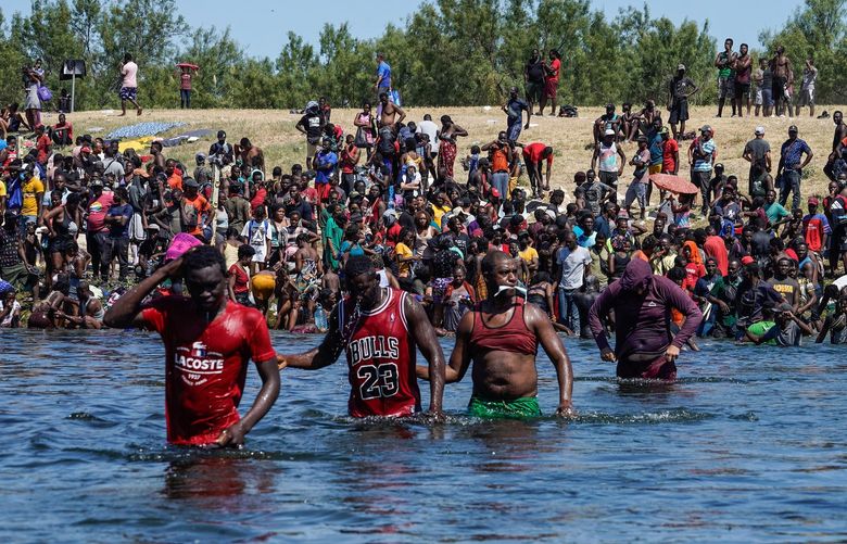 Haitian migrants, part of a group of over 10,000 people staying in an encampment on the U.S. side of the border, cross the Rio Grande river to get food and water in Mexico, after another crossing point was closed near the Acuna Del Rio International Bridge in Del Rio, Texas on Sunday, Sept. 19, 2021. (Paul Ratje/AFP/Getty Images/TNS) 27484013W 27484013W