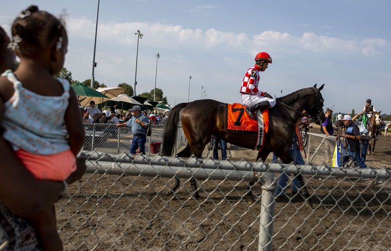 AUBURN- LONGACRES MILE – 081521
People watch as jockeys and horses prepare for the 7th race of the day before the 86th Longacres Mile Handicap on Sunday, August 15, at Emerald Downs in Auburn, WA.