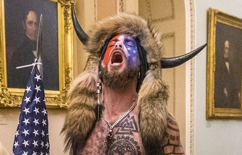 FILE – In this Jan. 6, 2021 file photo, supporters of President Donald Trump, including Jacob Chansley, right with fur hat, are confronted by U.S. Capitol Police officers outside the Senate Chamber inside the Capitol in Washington. Many of those who stormed the Capitol on Jan. 6 cited falsehoods about the election, and now some of them are hoping their gullibility helps them in court. Albert Watkins, the St. Louis attorney representing Chansley, the so-called QAnon shaman, likened the process to brainwashing, or falling into the clutches of a cult. Repeated exposure to falsehood and incendiary rhetoric, Watkins said, ultimately overwhelmed his client’s ability to discern reality. (AP Photo/Manuel Balce Ceneta, File) WX107