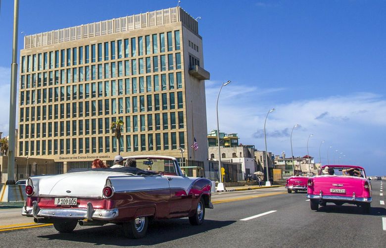 FILE – In this Oct. 3, 2017, file photo, tourists ride classic convertible cars on the Malecon beside the United States Embassy in Havana, Cuba. The Biden administration faces increasing pressure to respond to a sharply growing number of reported injuries suffered by diplomats, intelligence officers and military personnel that some suspect are caused by devices that emit waves of energy that disrupt brain function. The problem has been labeled the “Havana Syndrome,” because the first cases affected personnel in 2016 at the U.S. Embassy in Cuba. (AP Photo/Desmond Boylan, File) WX101
