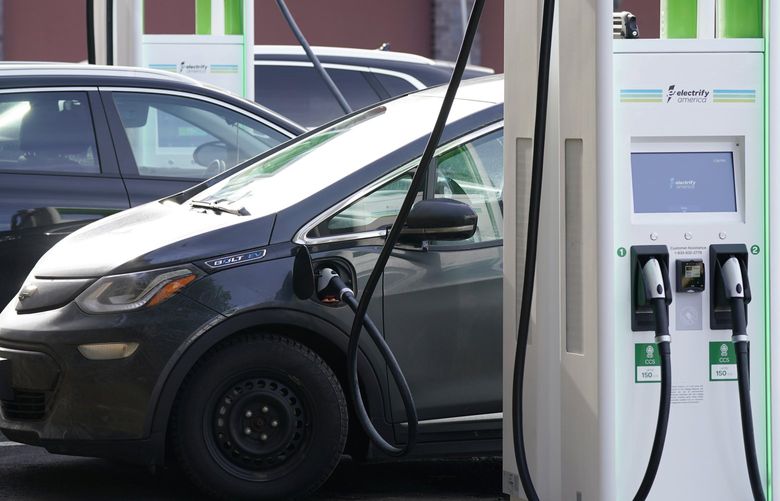 FILE – In this Dec. 21, 2020 file photo, a Chevrolet Bolt charges at an Electrify America site outside Colorado Mills outlet mall in downtown Lakewood, Colo. Electrify America, an electric vehicle charging network funded with money paid by Volkswagen as punishment for its emissions cheating scandal, says it plans to more than double its number of charging stations throughout the United States and Canada. The expansion will include 1,800 fast-charging stations and 10,000 individual chargers by 2025. (AP Photo/David Zalubowski, File)
