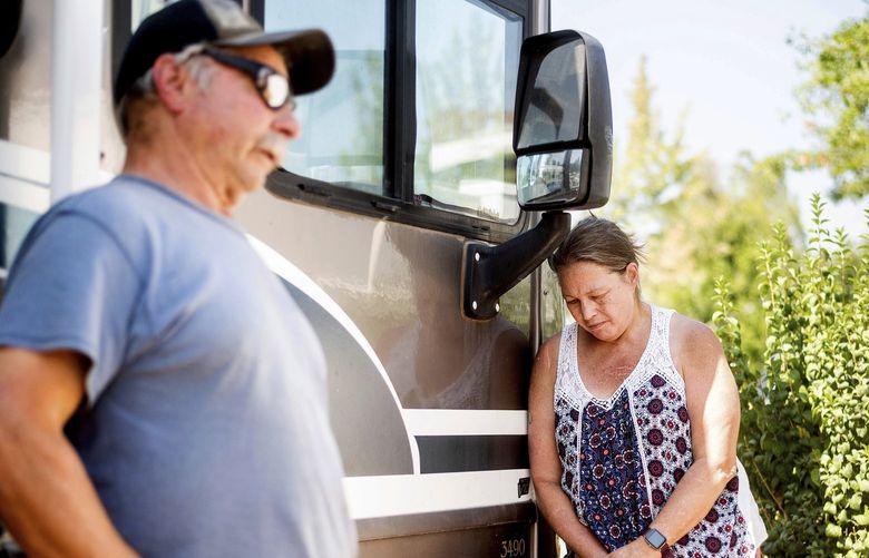 Kimberly Price leans against a donated motorhome she received with boyfriend John Hunter, left, on Sunday, Sept. 5, 2021, in Quincy, Calif. Hunter, who lost his home and business to the Dixie Fire, plans to live in the RV in Greenville. (AP Photo/Noah Berger) CANB102 CANB102