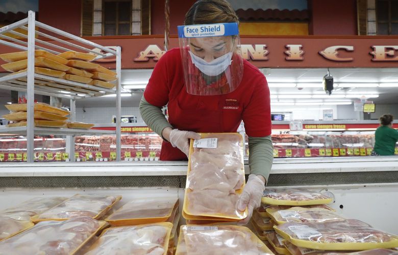 FILE – In this April 29, 2020 file photo, a worker restocks chicken in the meat product section at a grocery store in Dallas. Rising prices for a variety of commodities are contributing to a jump in prices at the consumer level in 2021, with Americans paying more for meat, gasoline, items they keep in their homes and even the homes themselves. (AP Photo/LM Otero)