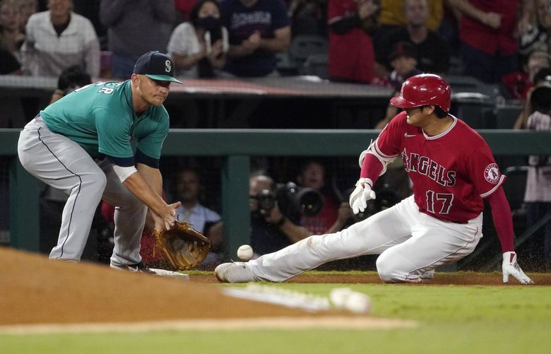 Los Angeles Angels designated hitter Shohei Ohtani, right, slides into third for a an RBI triple ahead of the tag of Seattle Mariners third baseman Kyle Seager during the third inning of a baseball game Saturday, Sept. 25, 2021, in Anaheim, Calif. (AP Photo/Mark J. Terrill) ANS118 ANS118