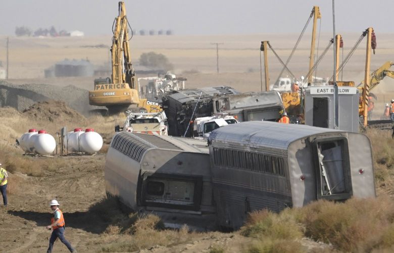 Overturned passenger railcars sit beside train tracks being repaired Monday, Sept. 27, 2021, near Joplin, Mont., where an Amtrak train derailed Saturday, killing three people and injuring others. Officials have said they will try to repair the tracks quickly, as rail transport is crucial to the area’s agricultural economy. (AP Photo/Ted S. Warren) MTTW129 MTTW129
