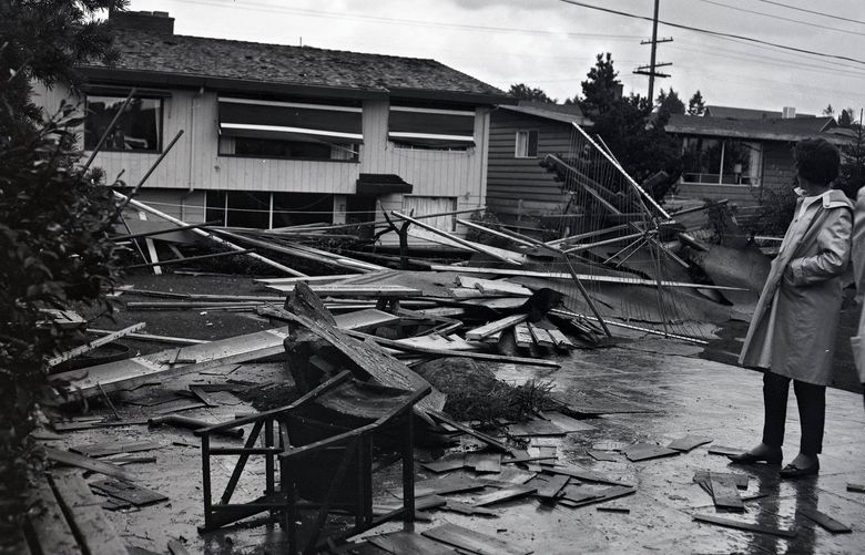 A bystander looks at damage after a tornado struck in northeast Seattle on Sept. 28, 1962.