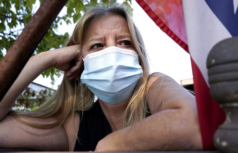 In this Monday, Sept. 27, 2021, photo Bronwyn Russell poses for a photo at her home in Des Plaines, Ill. Russell, who has had the COVID-19 vaccine, wears a mask anytime she leaves her Illinois home. â€œIâ€™m worried. I donâ€™t want to get sick,â€ says Russell. (AP Photo/Nam Y. Huh) ILNH104 ILNH104