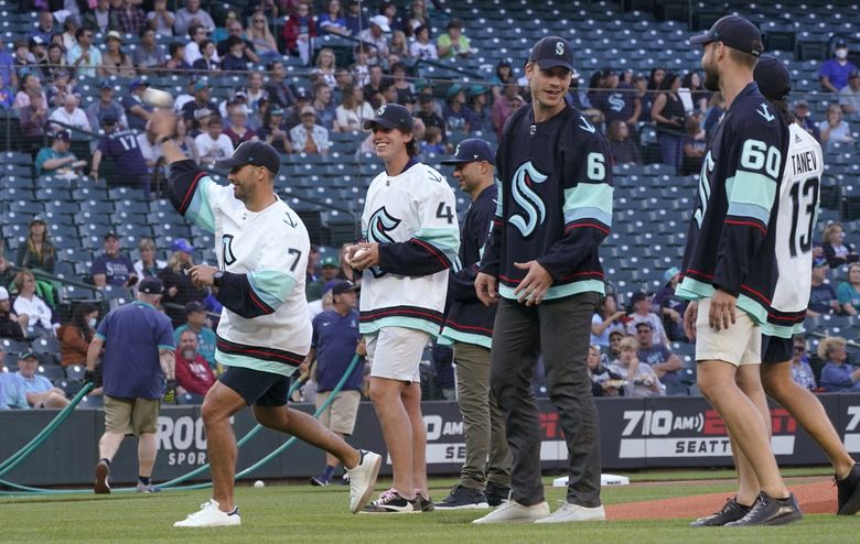 Seattle Kraken forward Jordan Eberle, left, throws out a first pitch as teammates watch before a baseball game between the Seattle Mariners and the Oakland Athletics, July 22, 2021, in Seattle. (Ted S. Warren / The Associated Press)