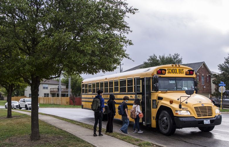 A school bus arrives late to pick up children on the way to school in San Antonio, Texas on Sept. 13, 2021. Just weeks into the new year, schools are struggling to fill jobs and school bus drivers in San Antonio have been forced to drive multiple routes, leaving students to wait for long periods. (Matthew Busch/The New York Times)