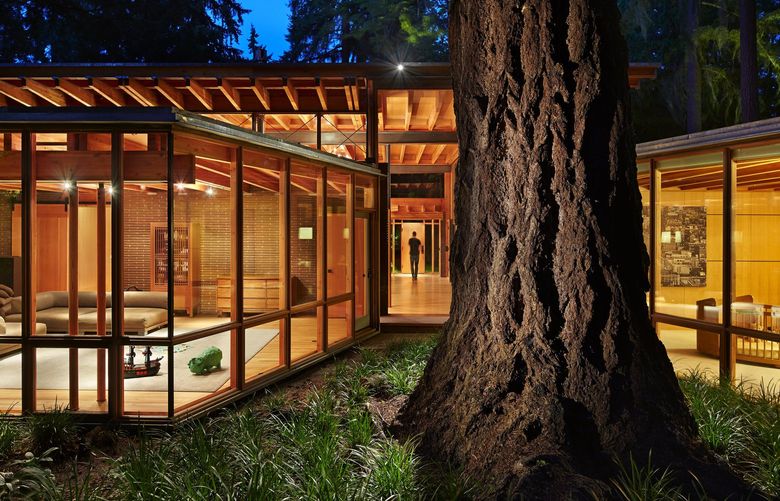 Expansive glass walls in the family room, left, and one of the kids’ rooms frame a majestic tree in a Beaux Arts Village home by architect Jim Cutler. All construction materials, including custom masonry, were locally sourced to reduce the impact on the environment.
(Benjamin Benschneider / The Seattle Times, 2015)