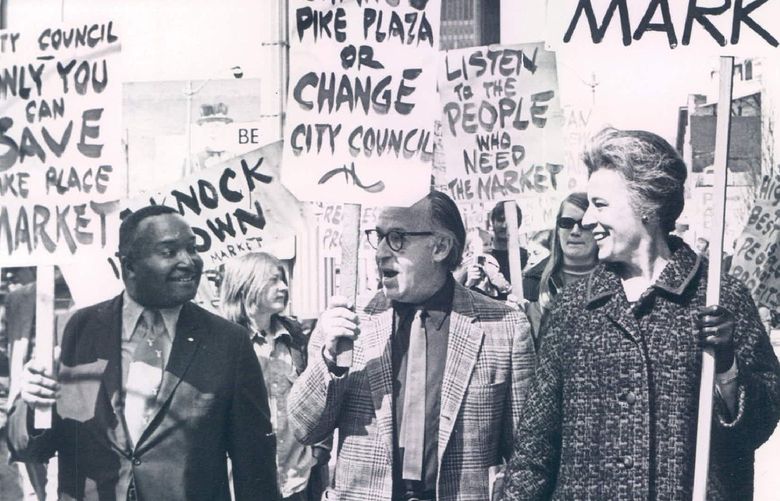 Councilman Sam Smith. left, and Councilwoman Mrs. Phyllis Lamphere were among the pickets at City Hall yesterday. Virtually all were protesting the Pike Plaza urban-renewal plan. Mrs. Lamphere, who supports the urban-renewal plan, was in a sense picketing pickets. At center was Victor Steinbrueck, architect and a leader of Friends of the Market, an organization backing preservation of the Pike Place Market area. Eighty to 100 persons picketed the building yesterday noon. Friends of the Market contends urban renewal would destroy the market’s spirit and result in mistreatment of market-area residents and businessmen. Some city officials contend the market is in disrepair and cannot be saved without the invest-ment of public money. (4/2/1971)