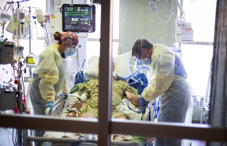 FILE – In this Aug. 31, 2021, file photo, Dr. William Dittrich M.D. looks over a COVID-19 patient in the Medical Intensive care unit (MICU) at St. Luke’s Boise Medical Center in Boise, Idaho. An advocacy group for seniors has filed a civil rights complaint against Idaho over the state’s “crisis standards of care” guidelines for hospitals overwhelmed during the coronavirus pandemic. Justice in Aging wants the U.S. Department of Health and Human Services to investigate Idaho’s health care rationing plan, contending that it discriminates against older adults by using factors like age in prioritizing which patients may get access to life-saving care. (AP Photo/Kyle Green, File) SEA506 SEA506