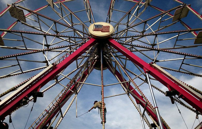 A carnival worker helps assemble the ferris wheel at the Grant County Fair grounds Monday, Aug. 15, 2005, in Moses Lake, Wash. (AP Photo/Coeur d’Alene Press, Jerome A. Pollos)

IDCOE101