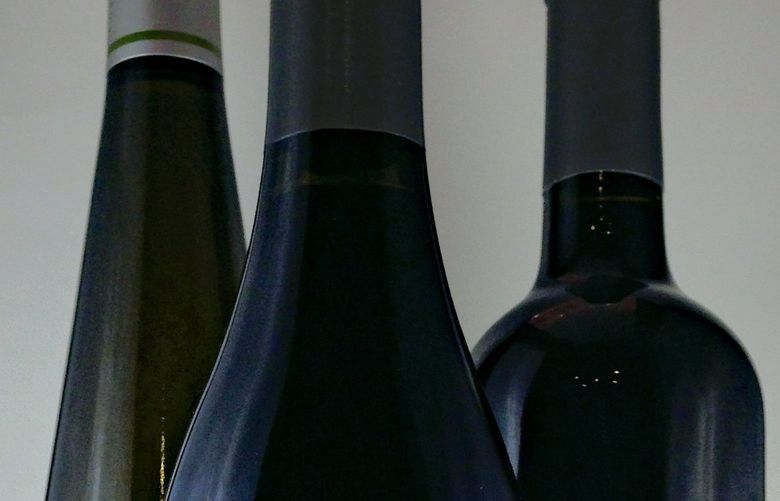 Three of the most common bottle shapes you’ll find on store shelves are Burgundy bottles (front) with sloping shoulders, tall hock bottles (left) and Bordeaux bottles (right) with high shoulders. (Photo by Andy Perdue/Great Northwest Wine)