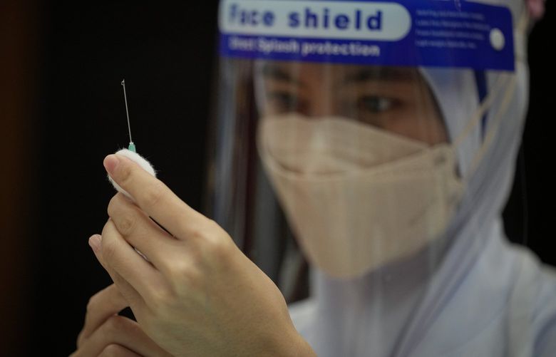 A Nurse prepares a dose of the Pfizer vaccine against the coronavirus disease (COVID-19) for a secondary school student at a vaccine center in Shah Alam, Malaysia, Monday, Sept. 20, 2021. (AP Photo/Vincent Thian) XVT102 XVT102