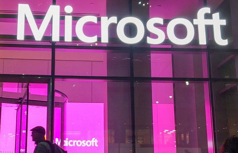 In this Nov. 10, 2016, photo, people walk near a Microsoft office in New York. Microsoft Corp. reports quarterly financial results on Thursday, Jan. 26, 2017. (AP Photo/Swayne B. Hall) NYSB401
