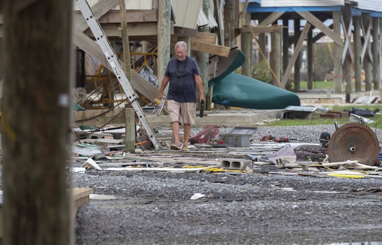 Albert Kovatch looks at the damage to his home from Hurricane Ida in Grand Isle, La for the first time, Friday, Sept. 3, 2021. Utility executives say more than 25,000 workers from 40 states are trying to fix damaged poles, more than 2,200 broken transformers and more than 150 destroyed transmission structures. Ida destroyed the cityâ€™s electrical grid and left more than 1 million customers in Louisiana without power. (Scott Clause/The Daily Advertiser via AP) LALAF502 LALAF502